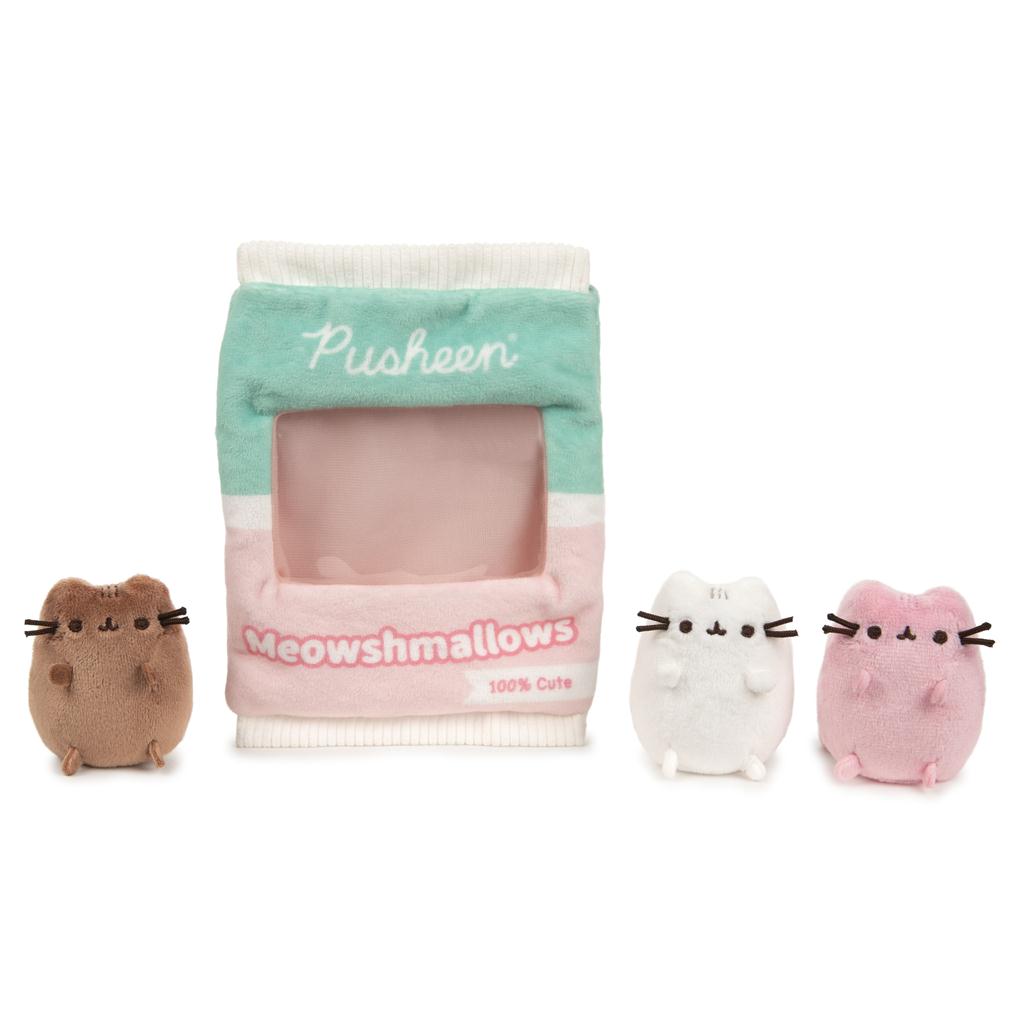 Three Pusheen cat plush toys and a container.