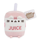 A Pusheen plush toy designed to look like a pink juice box. It has a white straw and a tag with a cat on it.