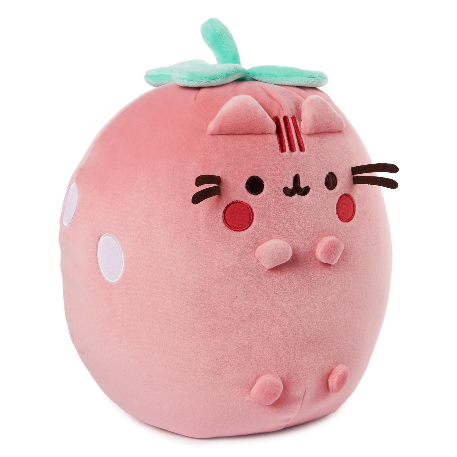 Pink strawberry-shaped cat plush toy with light green leaves.