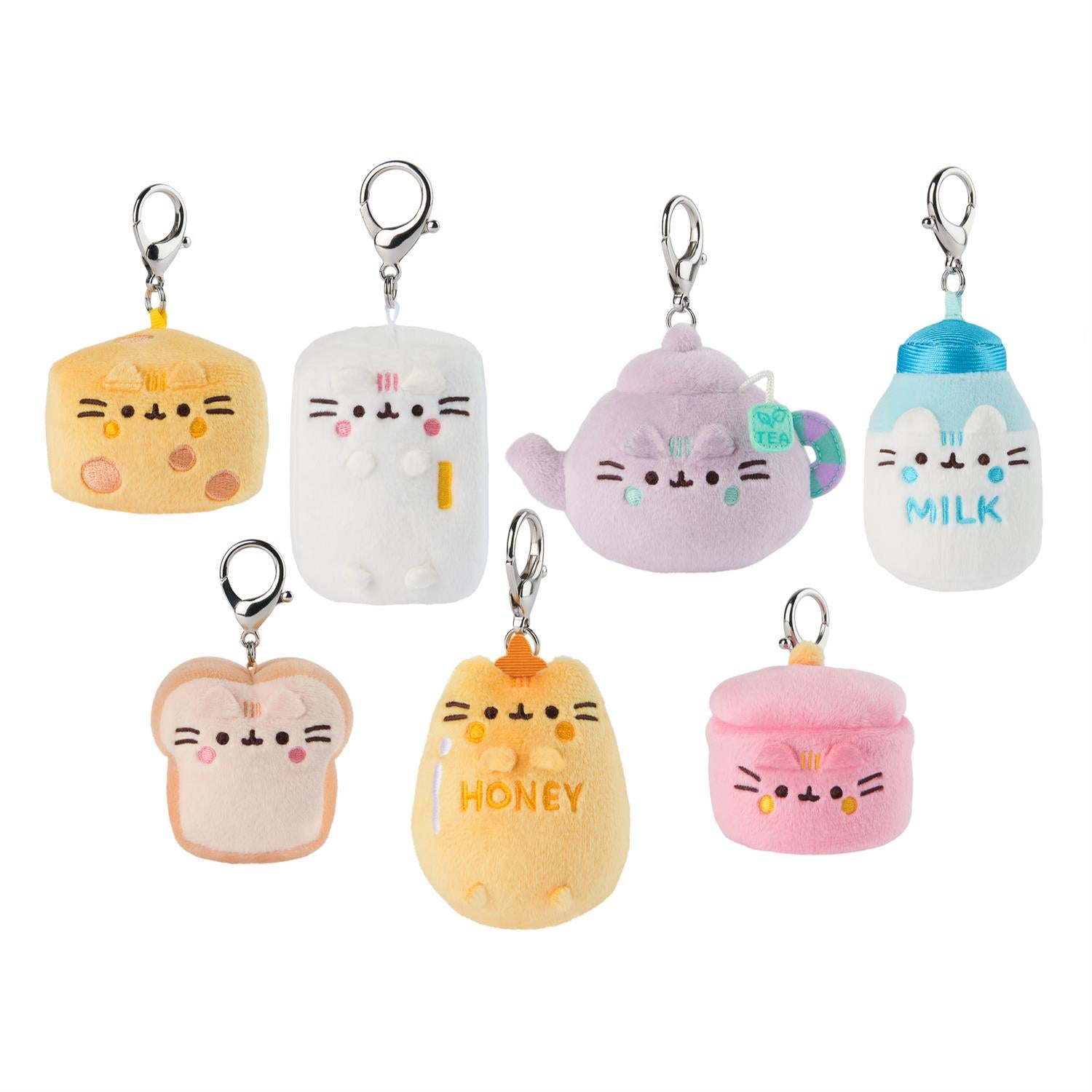 A collection of seven plush keychains in various food-themed shapes, each with a cute cat face design, featuring a range of colors and textures.