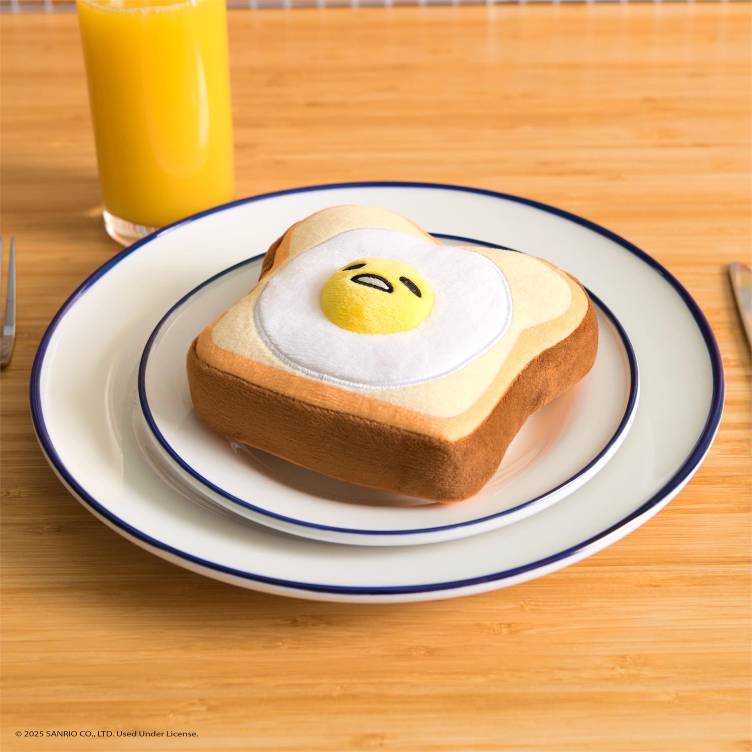 Toast-shaped plush toy topped with a sunny-side-up egg on a plate.