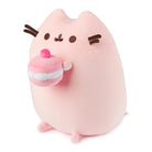 Pink Pusheen cat plushie holding a pink cupcake.