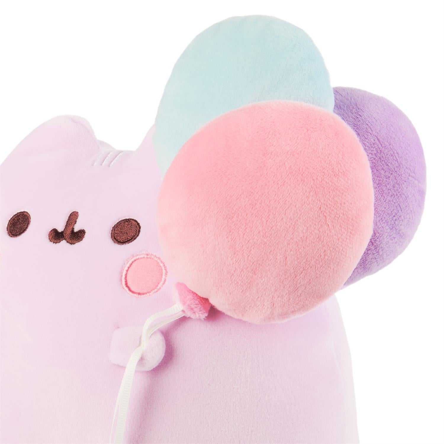 Stuffed pink Pusheen cat with pastel balloons.