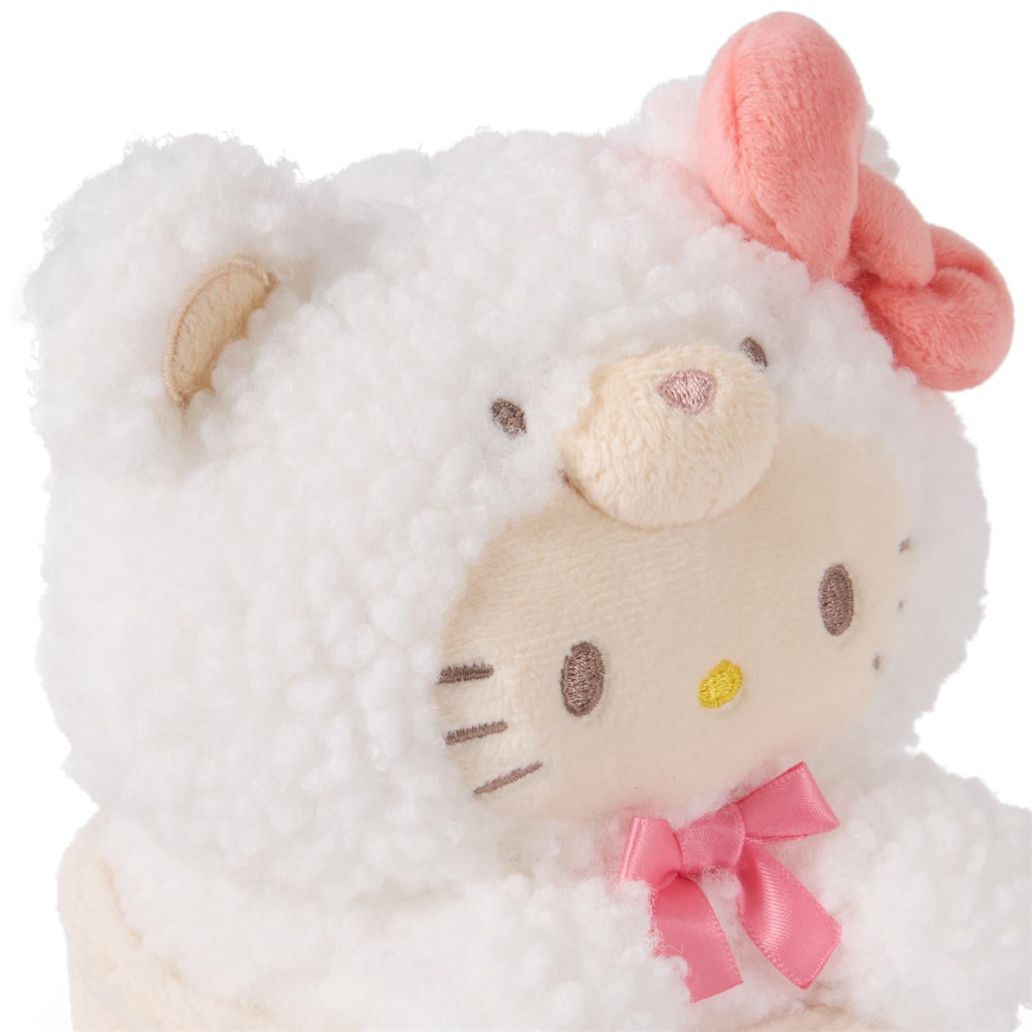 White, fuzzy Hello Kitty plush with a pink bow.