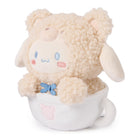 Stuffed beige lamb in white teacup with blue bow.