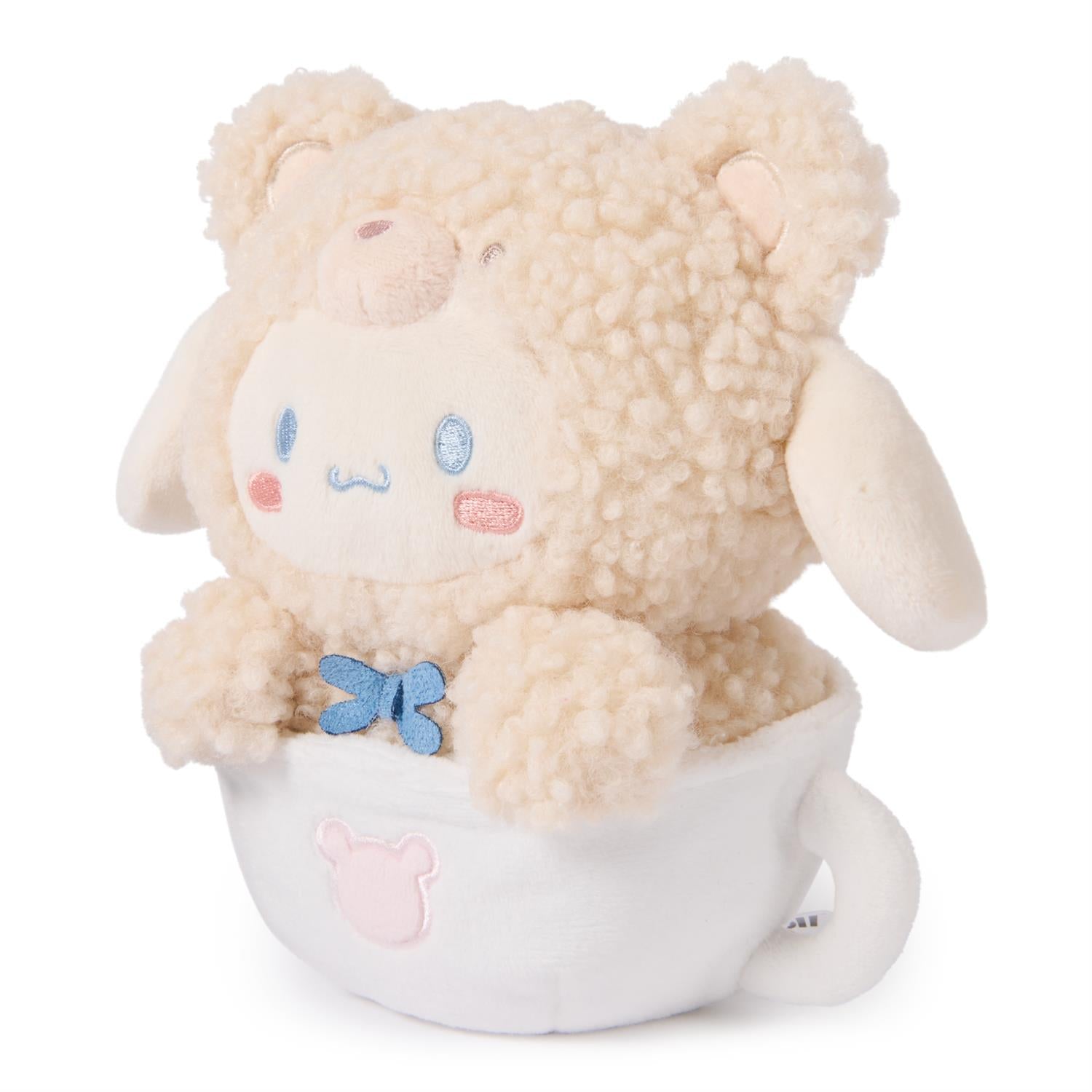 Stuffed beige lamb in white teacup with blue bow.