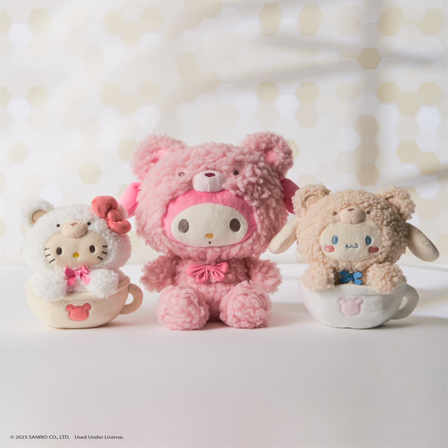 Three Sanrio character plush toys in teacups.
