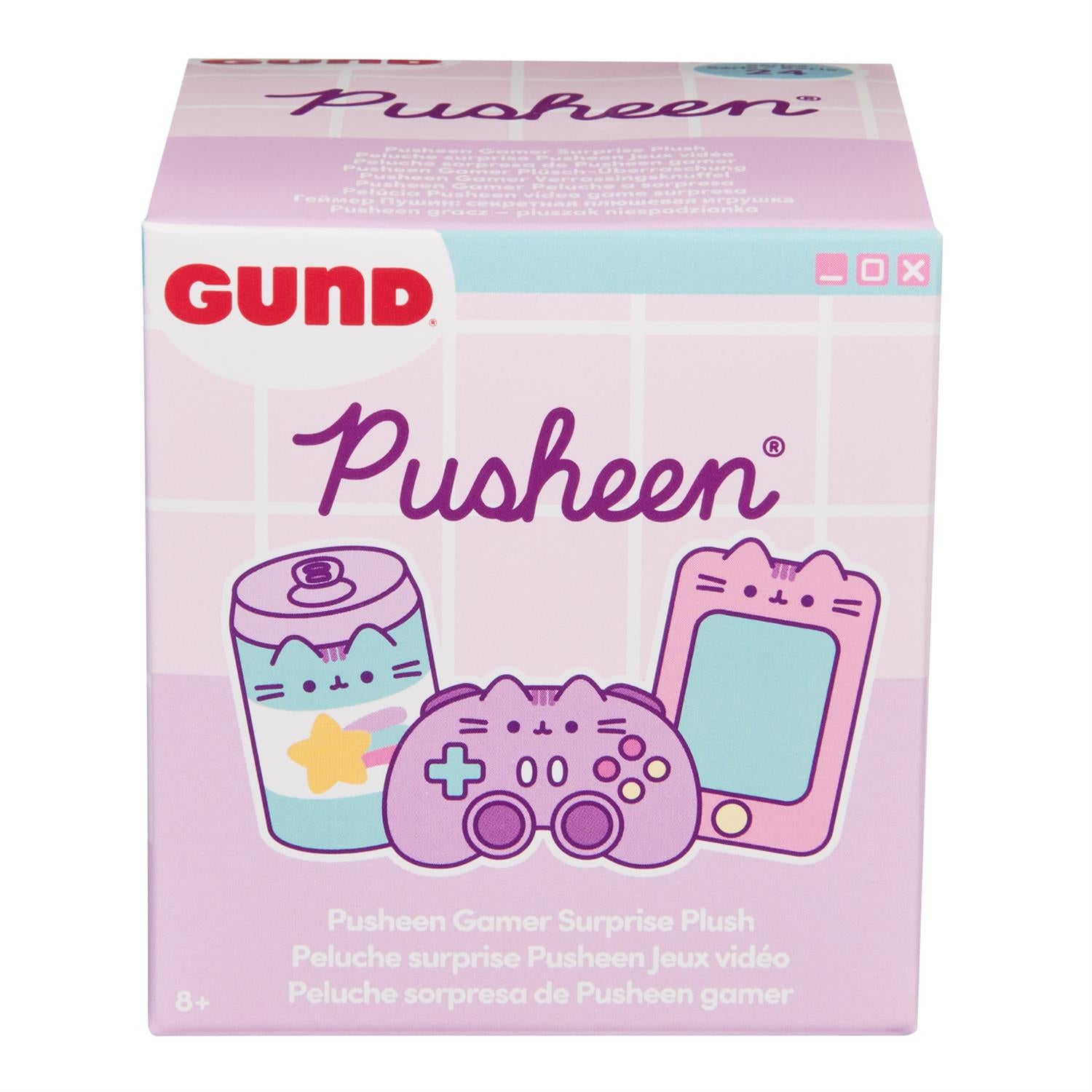 A box for a Pusheen Gamer Surprise Plush, featuring a pink and white color scheme with images of a Pusheen-themed soda can, gamepad, and smartphone. The box also has the Gund logo and includes text in English, French, Spanish, and other languages.