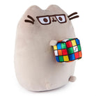 Tan plush Pusheen cat toy with glasses, holding a Rubik's cube.