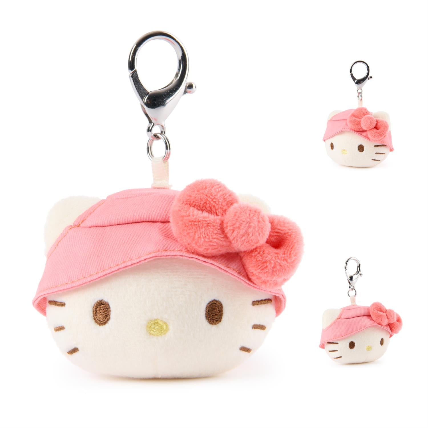 Plush keychain of a cartoon character with a pink headband and bow on a white background