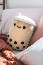Cute bubble tea plushie on a bed.