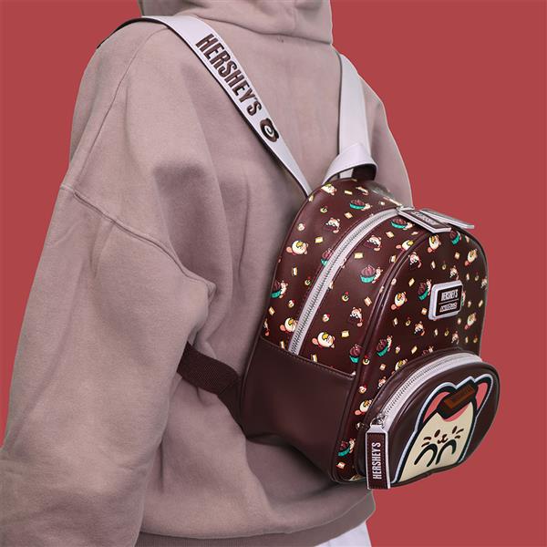 Person wearing a light brown hoodie and a Hersheys-themed backpack.