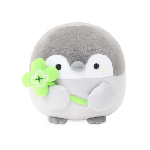 Gray plush penguin toy holding a green four-leaf clover.