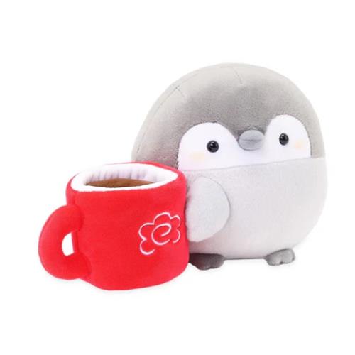 Stuffed gray penguin toy next to a red coffee mug.