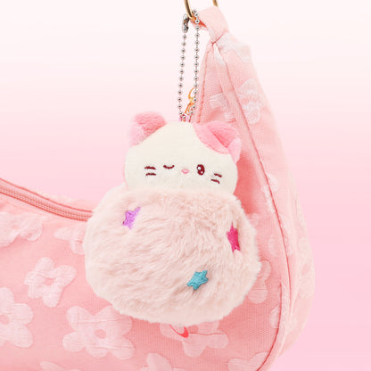 Fluffy pink cat-shaped keychain on a pink floral background
