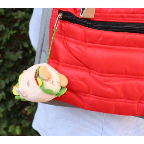 Close up of red quilted backpack with plush sandwich keychain.