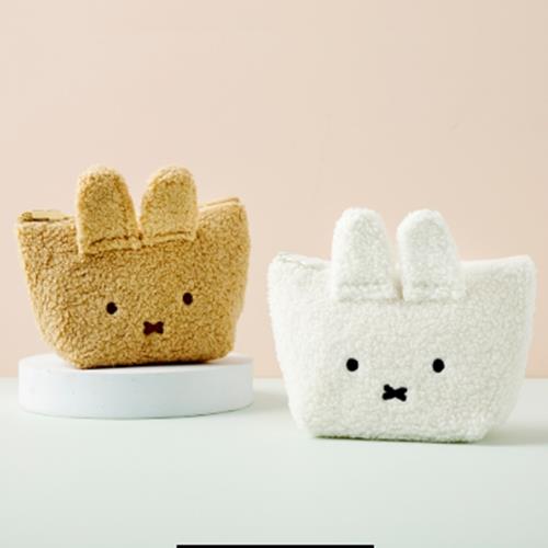 Two plush rabbit-shaped tote bags, one beige and one white, on a light surface.