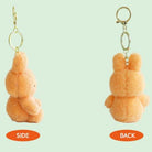 Two orange bunny keychains, shown from side and back, hanging against a light green background.