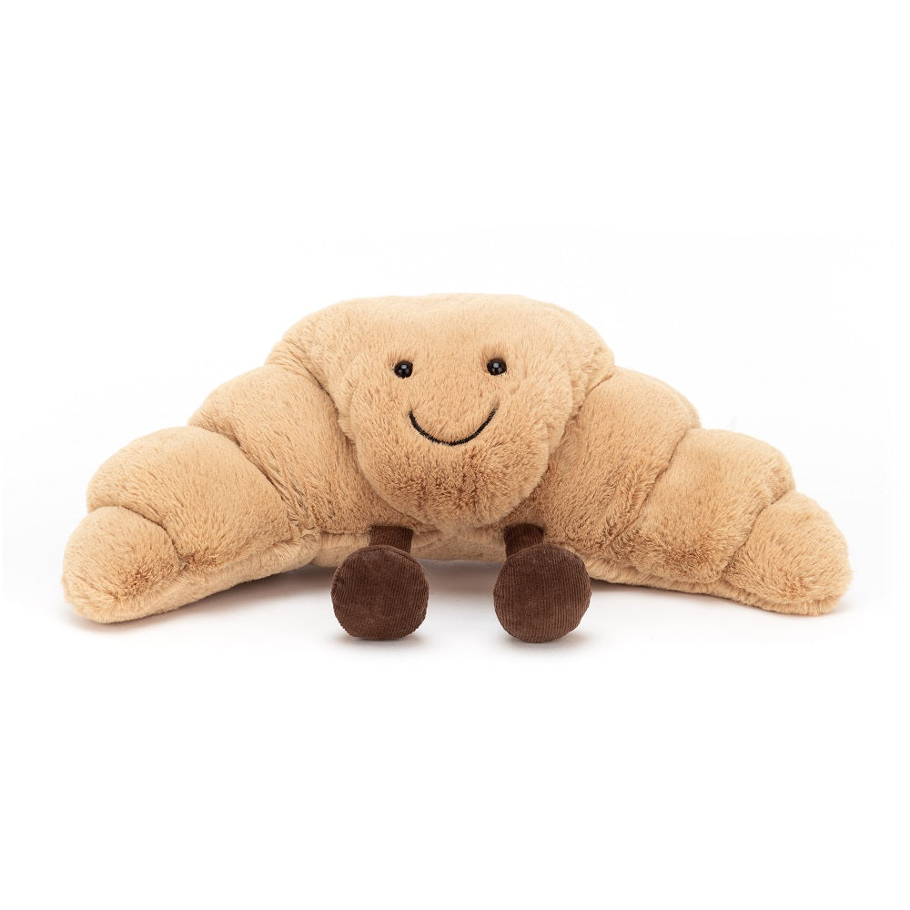 A stuffed, croissant-shaped plushie with a smiling face and small brown legs.