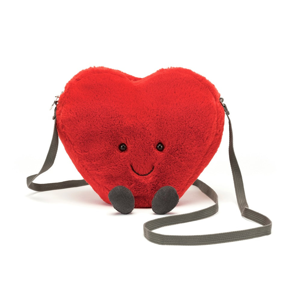 Red, plush, heart-shaped purse with gray straps and a smiling face.