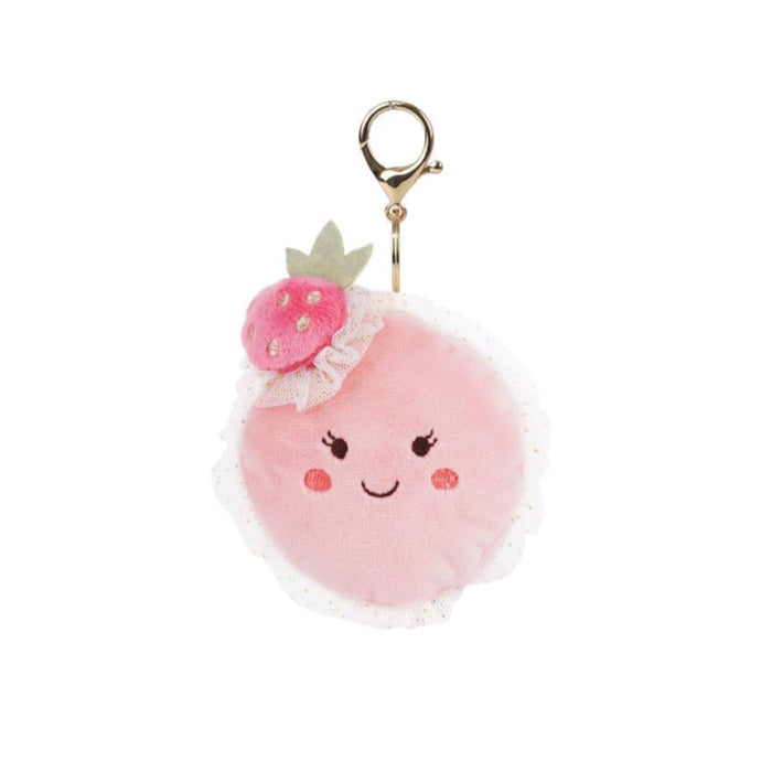 Pink pom-pom keychain with a smiling face and flower on a white background