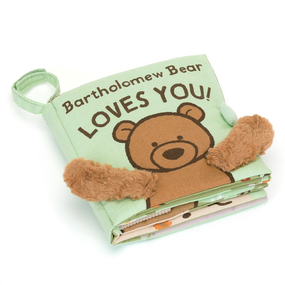 Light green fabric baby book with a brown bear illustration and fuzzy bear arm accents.