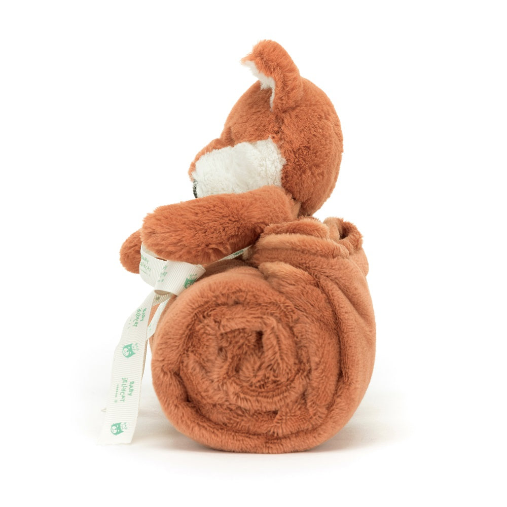 Brown plush fox toy with a rolled blanket and white ribbon.