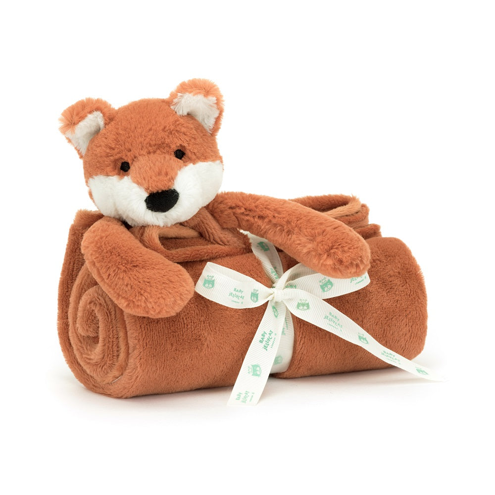 A plush toy fox wrapped in a rolled-up blanket and tied with a ribbon.