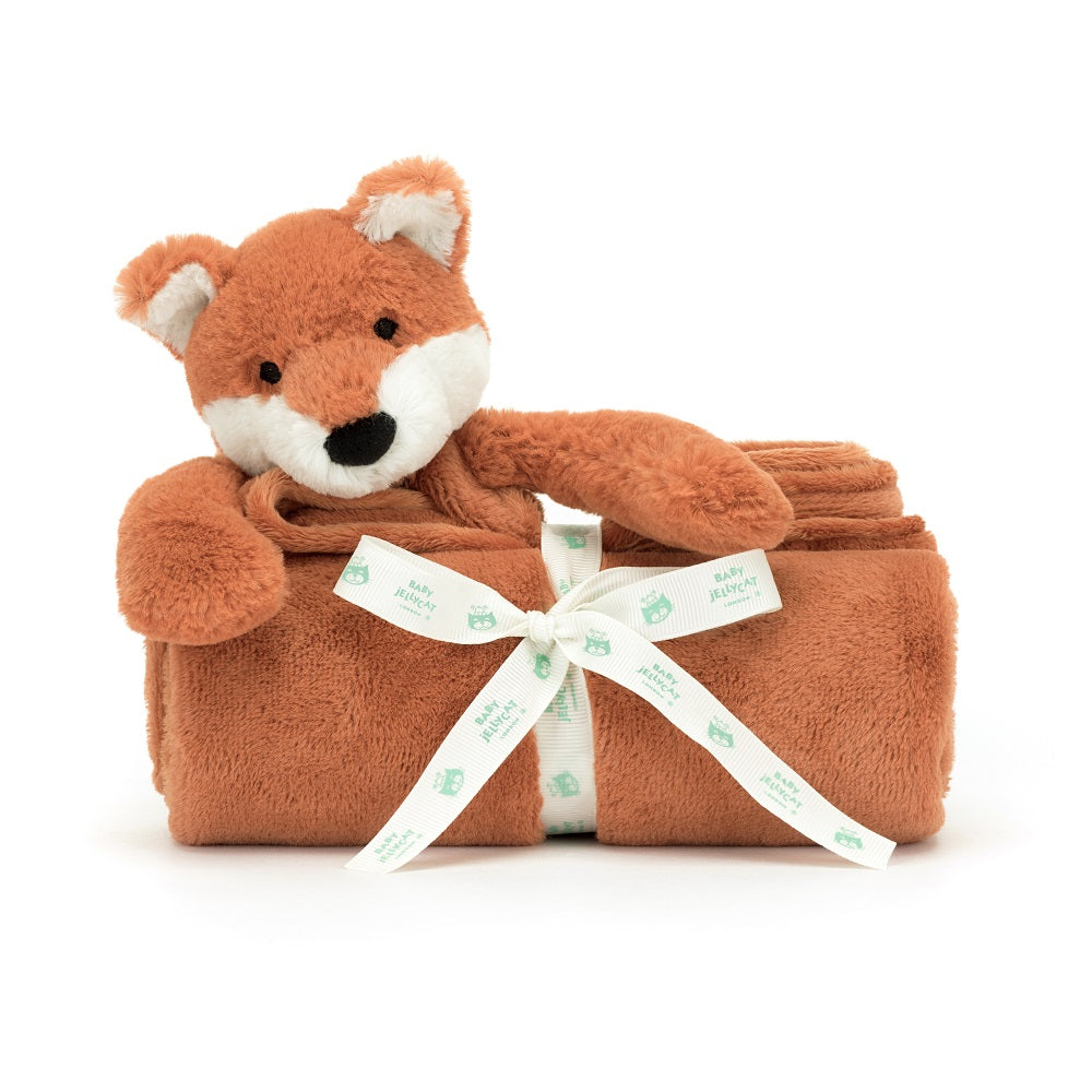 Orange plush fox toy in rolled blanket with ribbon.