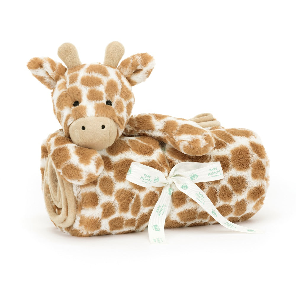Stuffed giraffe toy wrapped in a blanket with a white bow.