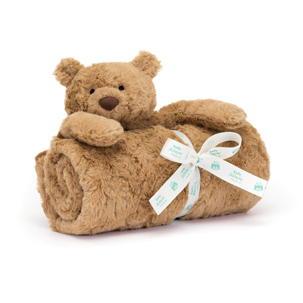 Brown plush teddy bear wrapped in a blanket with a bow.