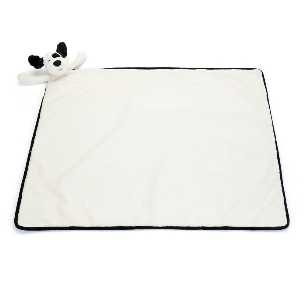 White baby blanket with black trim and a plush black and white dog.