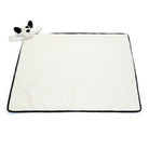 White baby blanket with black trim and a plush black and white dog.