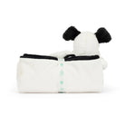 White plush dog toy with black ears in a white plush blanket secured with a ribbon.