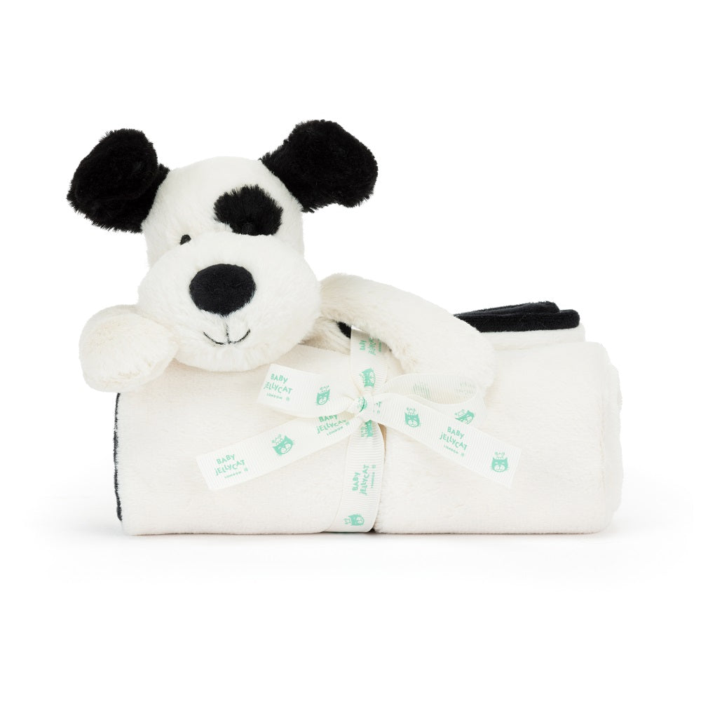 White and black plush dog toy with a matching blanket, tied with a branded ribbon.