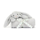 Gray stuffed bunny rabbit on a rolled blanket tied with a "Baby Jellycat" ribbon.