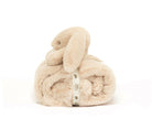 Beige plush bunny toy rolled into a blanket and secured with a branded ribbon.