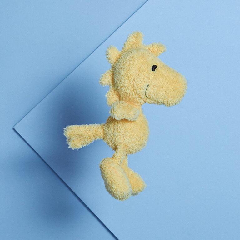 Yellow stuffed horse on blue background.