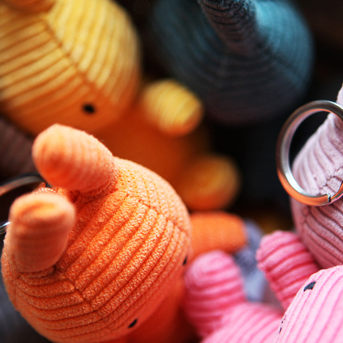 Close-up of colorful stuffed toy animals with keyrings.