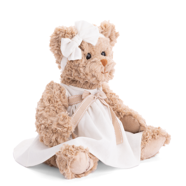 Teddy bear in a white dress with a bow on a white background