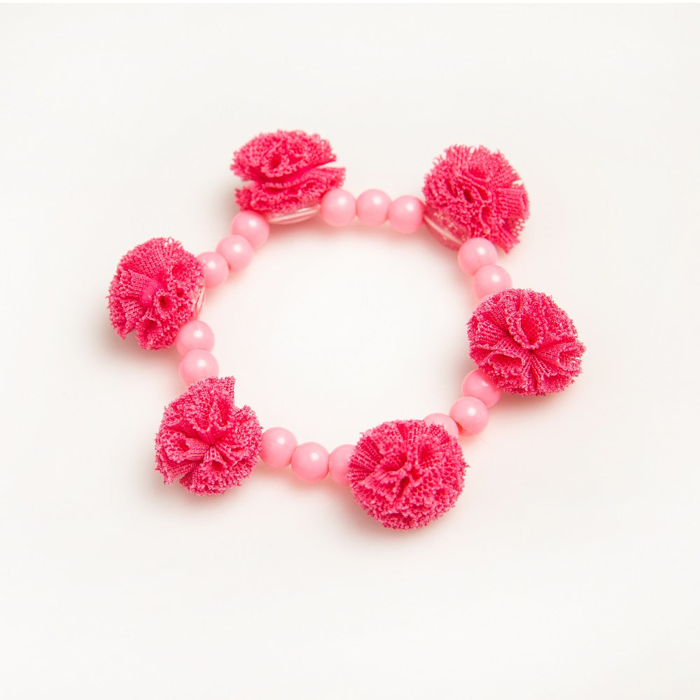 Pink beaded bracelet with pink pom-poms.