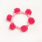 Pink beaded bracelet with pink pom-poms.