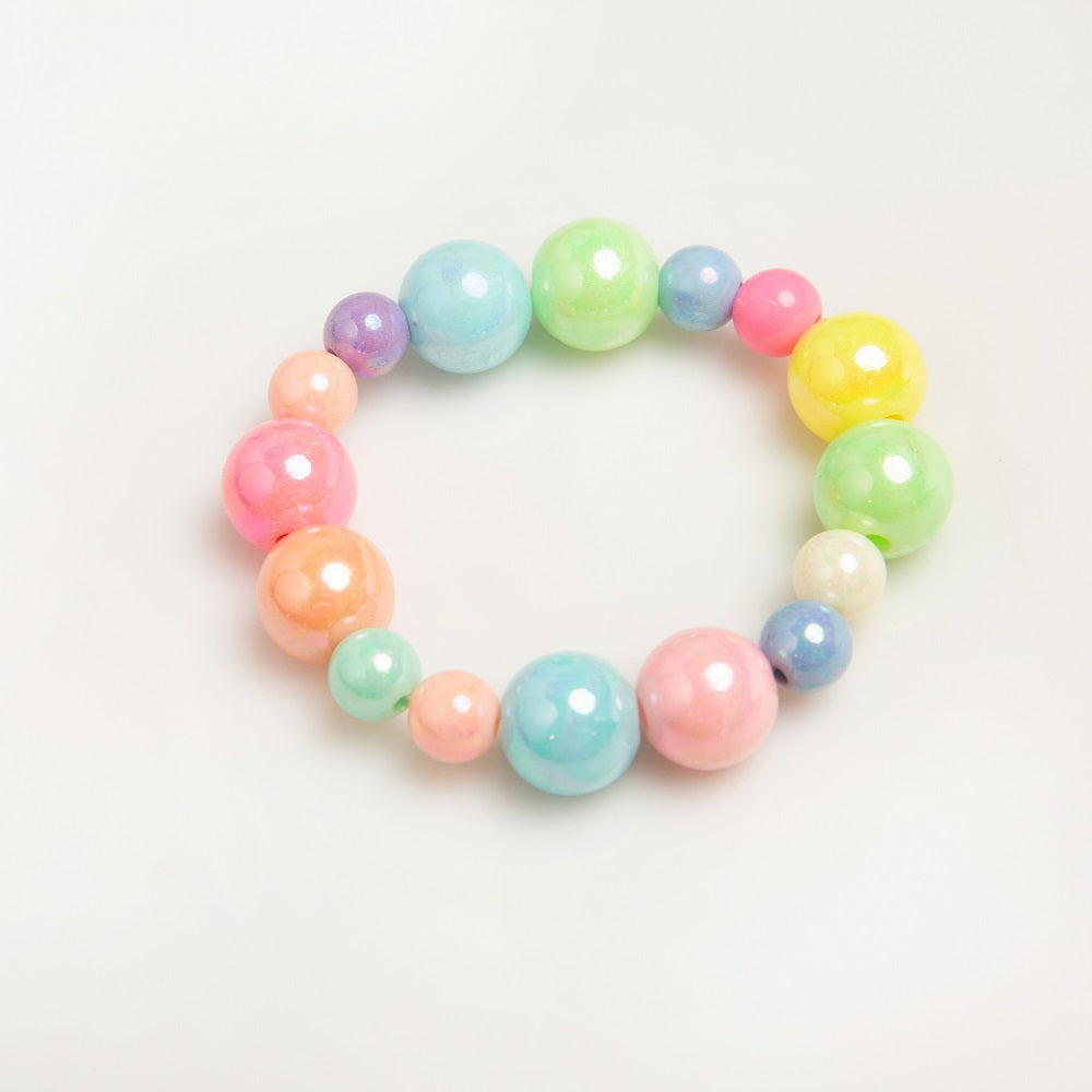 A colorful bead bracelet with pastel shades of pink, blue, green, yellow, and orange on a white surface.