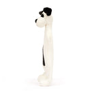 Side view of a white plush dog toy with black spots.