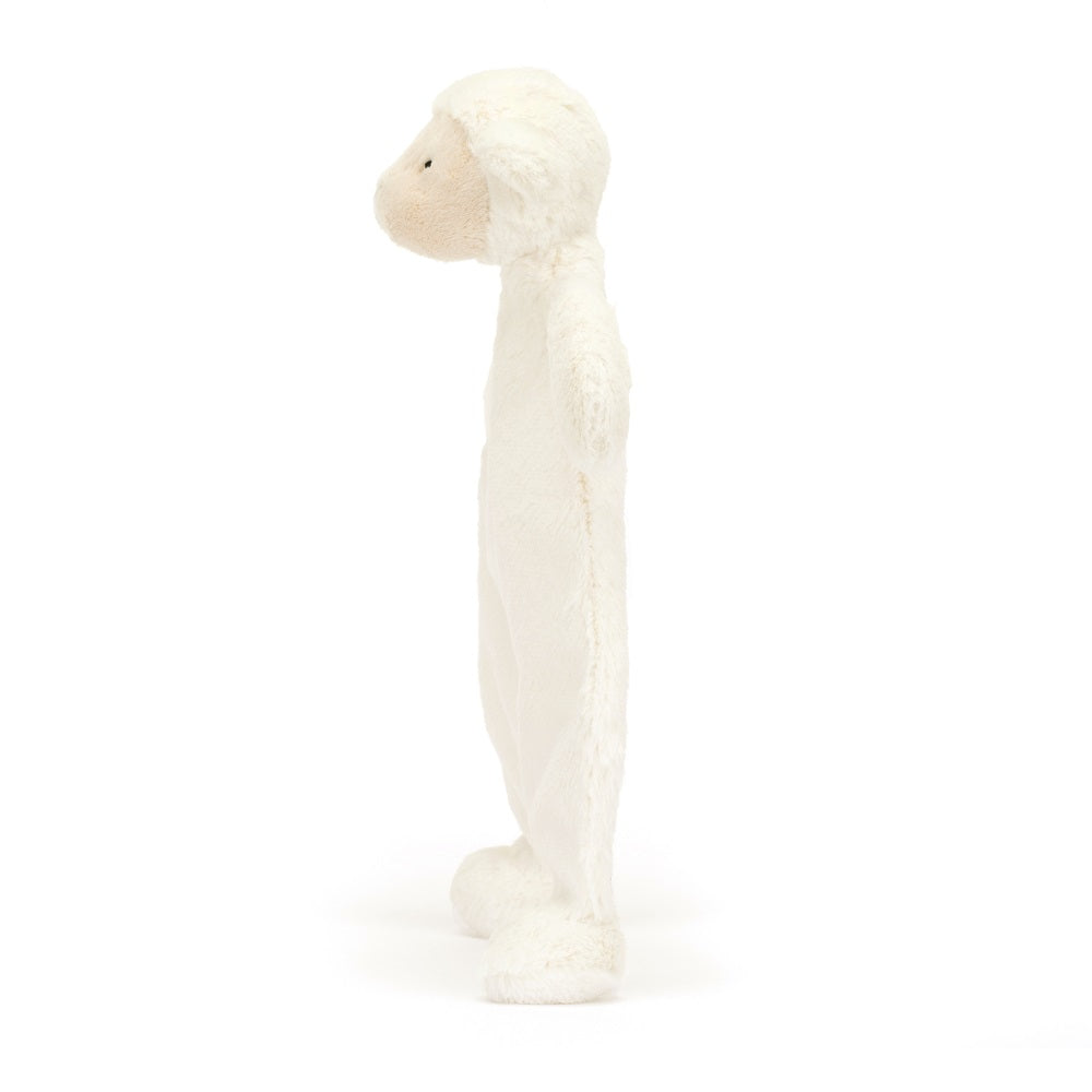 Side view of a white, soft, plush lamb toy.