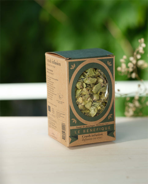 Close-up of a cardboard box labeled "LE BÉNÉFIQUE" filled with dried herbs.