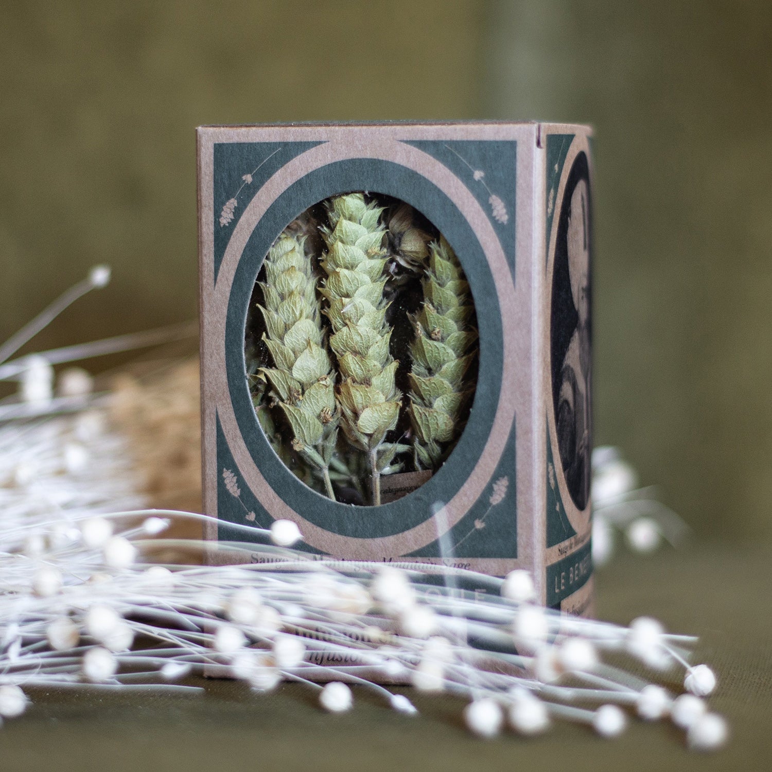 Close-up of a box of dried herbs surrounded by dried flowers.