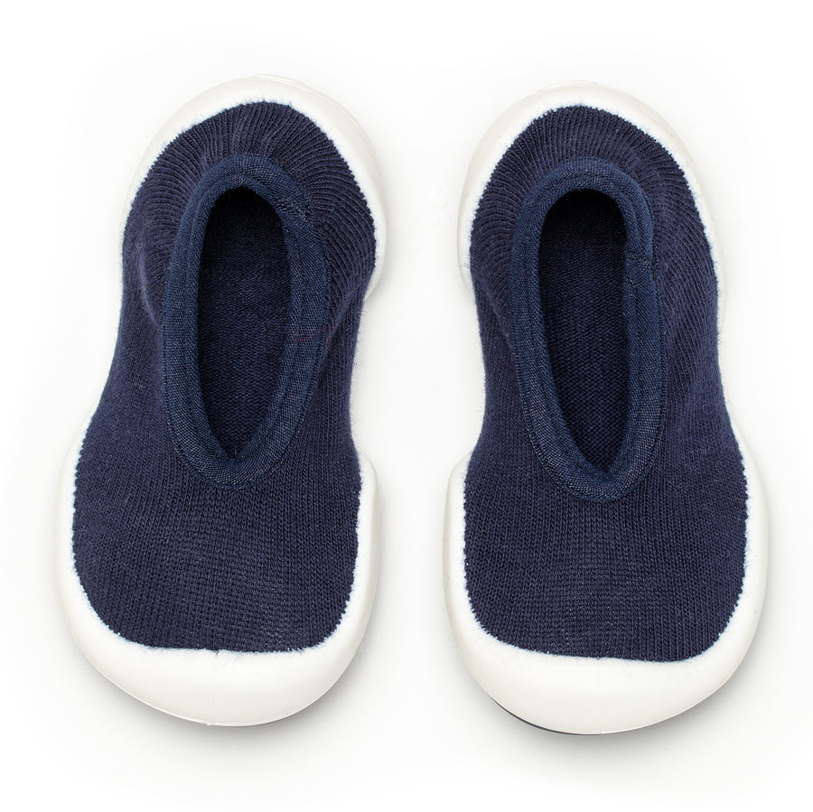 A pair of navy blue sock-shoes with white soles.