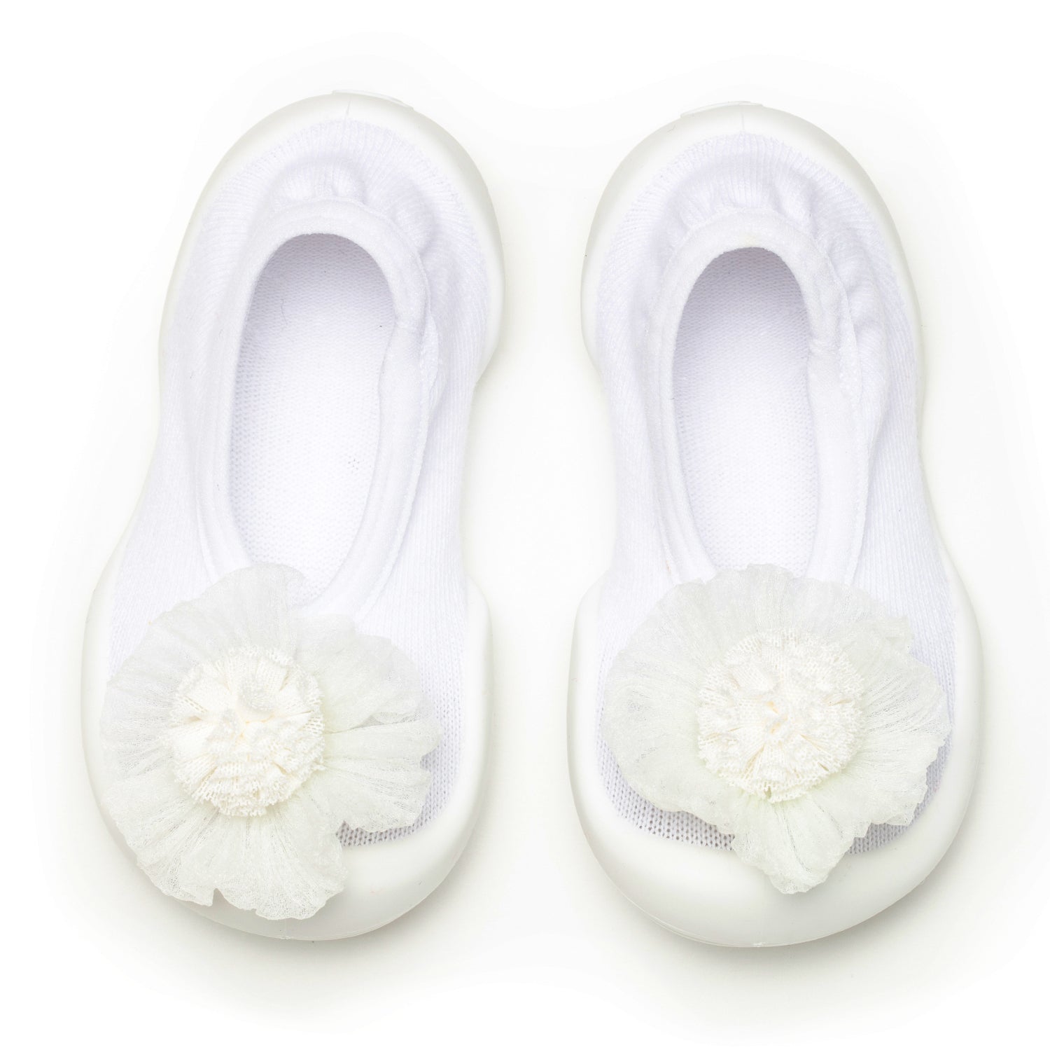 A pair of white baby shoes with a flower design.