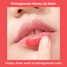 Close-up of lips with pomegranate honey lip balm being applied.